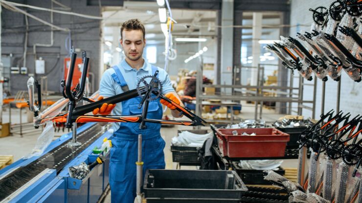 Un technicien en train de monter un vélo de route dans une usine