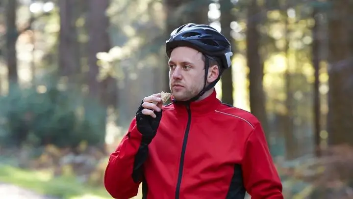 Un cycliste professionnel qui s'alimente et qui se demande comment progresser en vélo en montagne